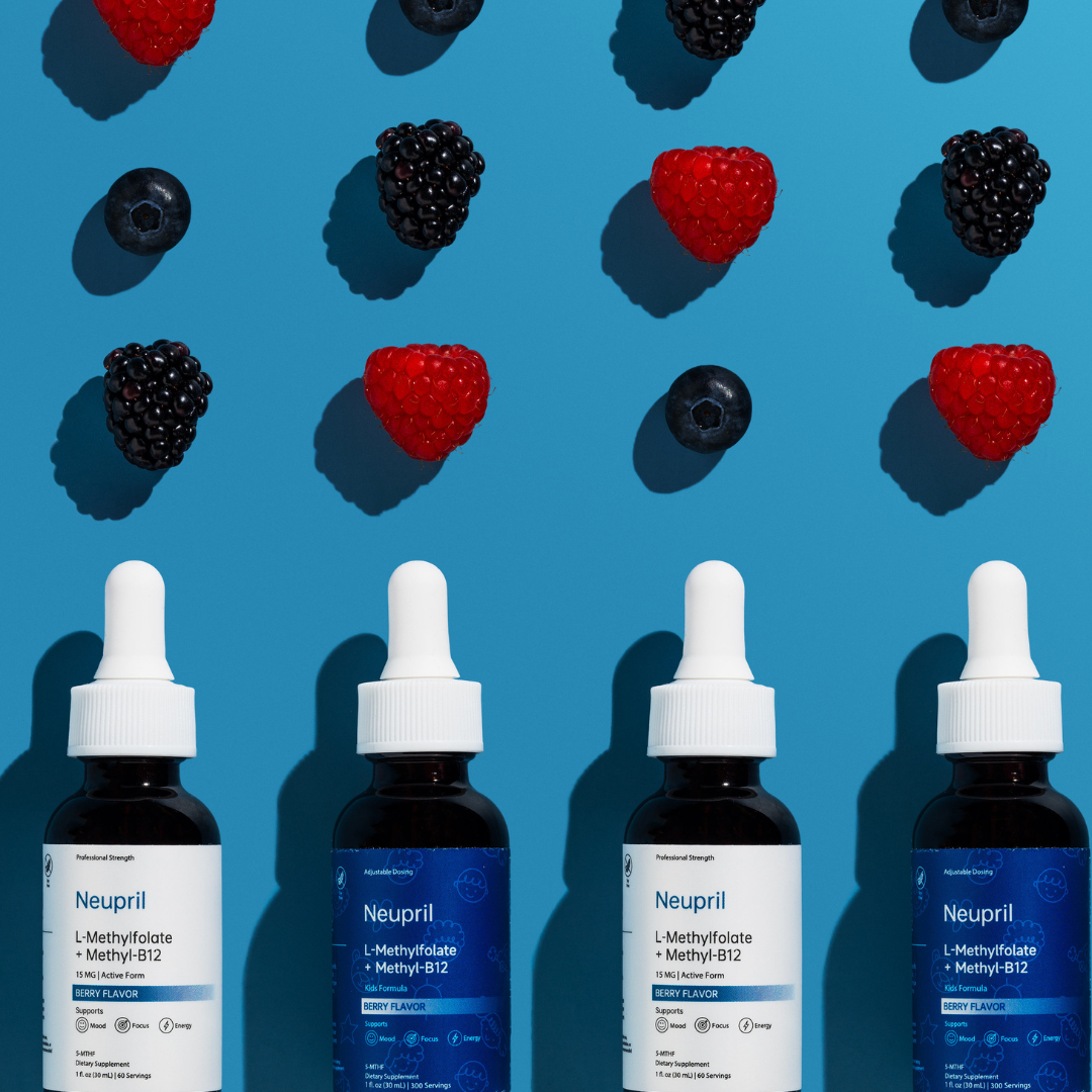 Four bottles of Neupril L-Methylfolate and Methyl-B12 liquid supplements (alternating original and Kids Formula) lined up against a vibrant blue background with fresh raspberries, blackberries, and blueberries floating above them