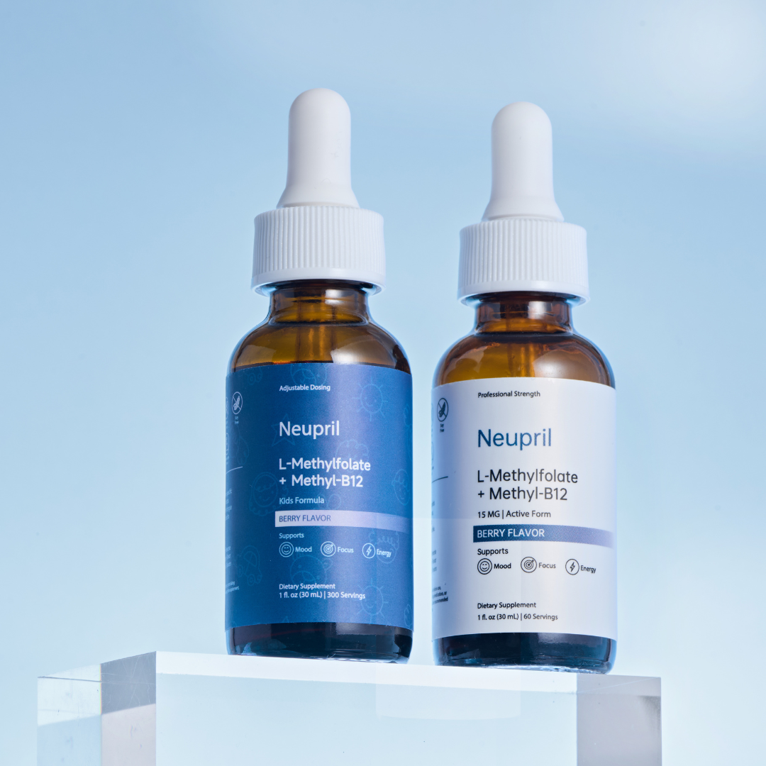 Two amber glass dropper bottles of Neupril L-Methylfolate + Methyl-B12 liquid supplements in Berry Flavor. On the left is the blue Kids Formula; on the right is the white Professional Strength 15mg bottle. Both sit on a clear acrylic block against a bright blue background.